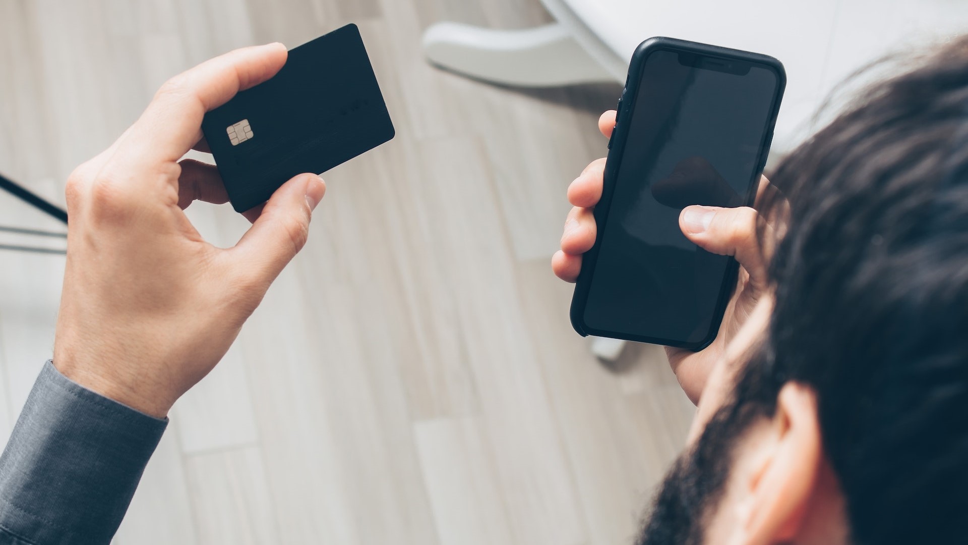 man holding phone and bank card