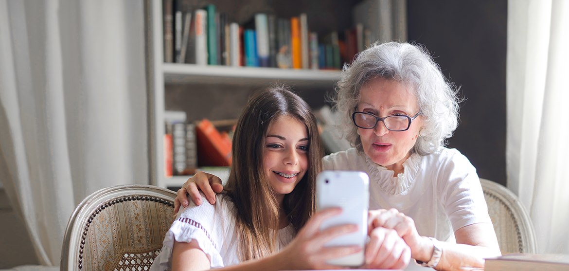 Woman Looking At Phone With Granddaughter Rrif