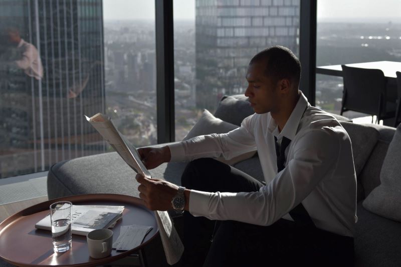 Business Man Reading Newspaper In High Rise