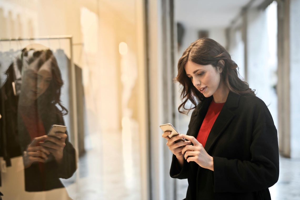 Woman Looking At Credit Card Balance Outside A Store Woman Looking At Credit Card Balance Outside A Store