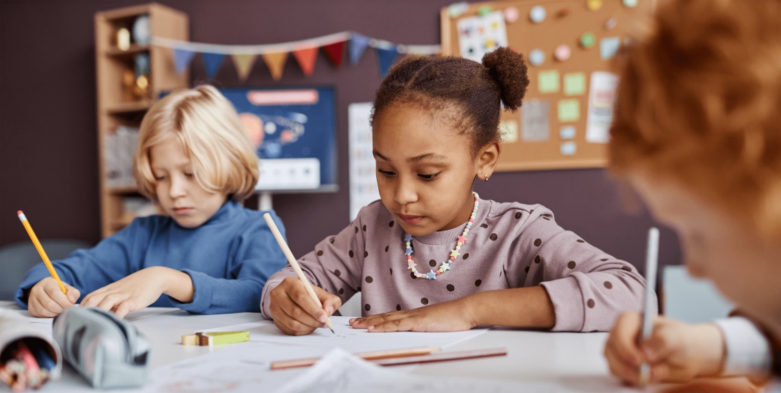 children writing at a school table